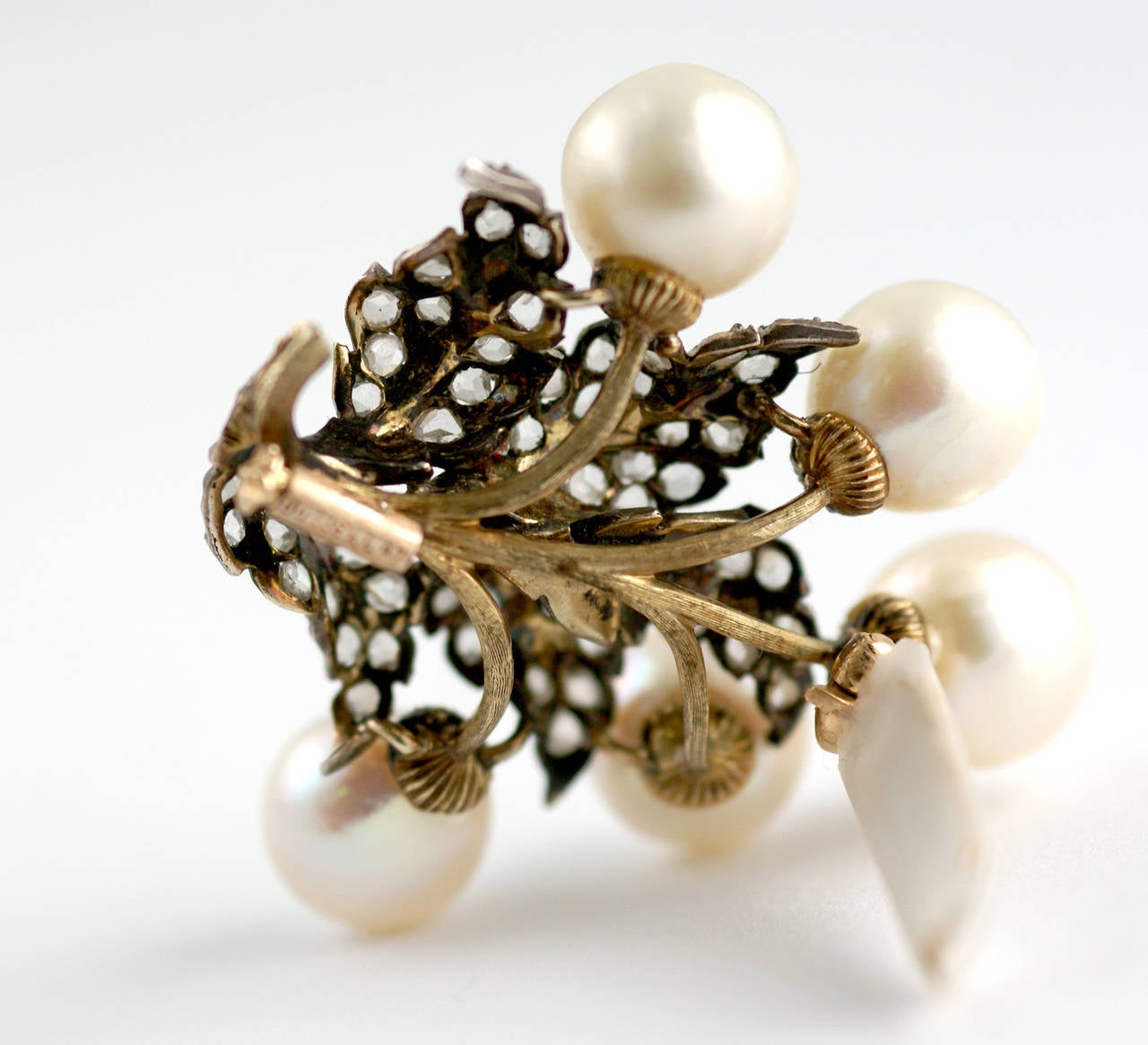 A sophisticated brooch in the typical style of the house, presenting pearls and rose cut diamonds on a mixed 18kt white and yellow gold mounting. Signed Buccellati, circa 1965.
