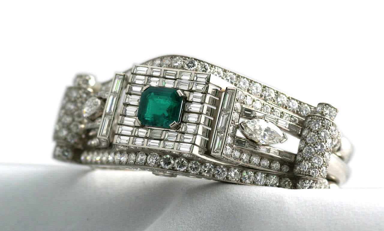An important platinum bracelet of exquisite craftsmanship, highlighted by approximately 20 cts of mixed cut diamonds, centering a fine quality 4.5 carat emerald of Colombian origin. Made in France, circa 1935.