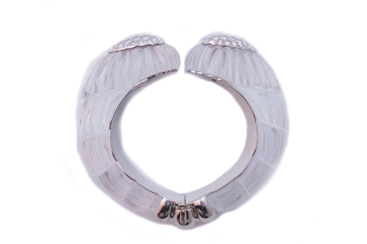 A rare bracelet by the quintessential American designer David Webb, presenting two large elements of very fine rock crystal carved in undulating forms and embellished, on their crowns, by a pave of fine brilliant cut diamonds. Platinum mounting.