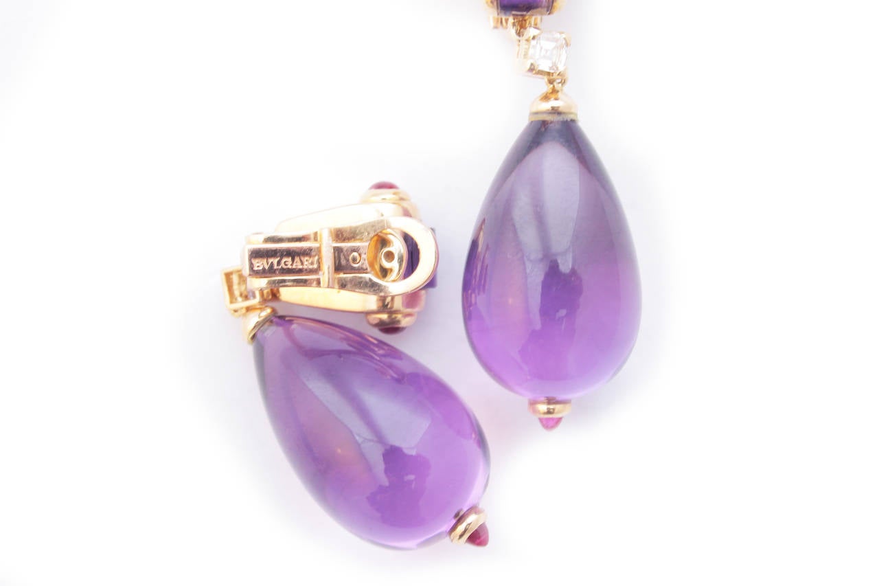 A pair of earrings manufactured by Bulgari in the mid 1980s, of geometrical design, sustaining two very fine cabochon amethyst drops, embellished by square cut amethysts on the top, two brilliant cut diamonds in the centre (weighing a total of apprx