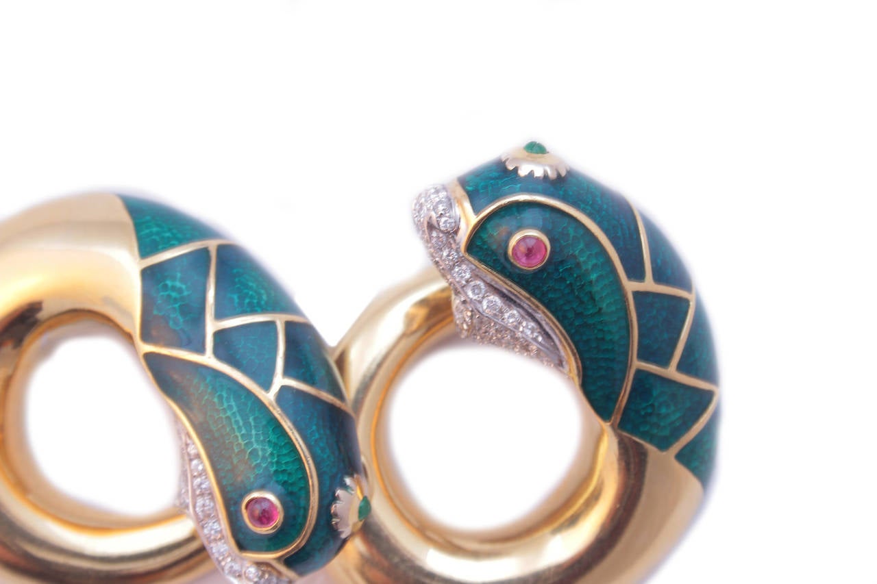 A pair of earrings representative of marine figures, embellished by diamond pave (1ct total weight), cabochon ruby eyes, emeralds, and a fine greenish blue enamel work. 18k yellow gold mounting. Italian craftsmanship, circa 1975.