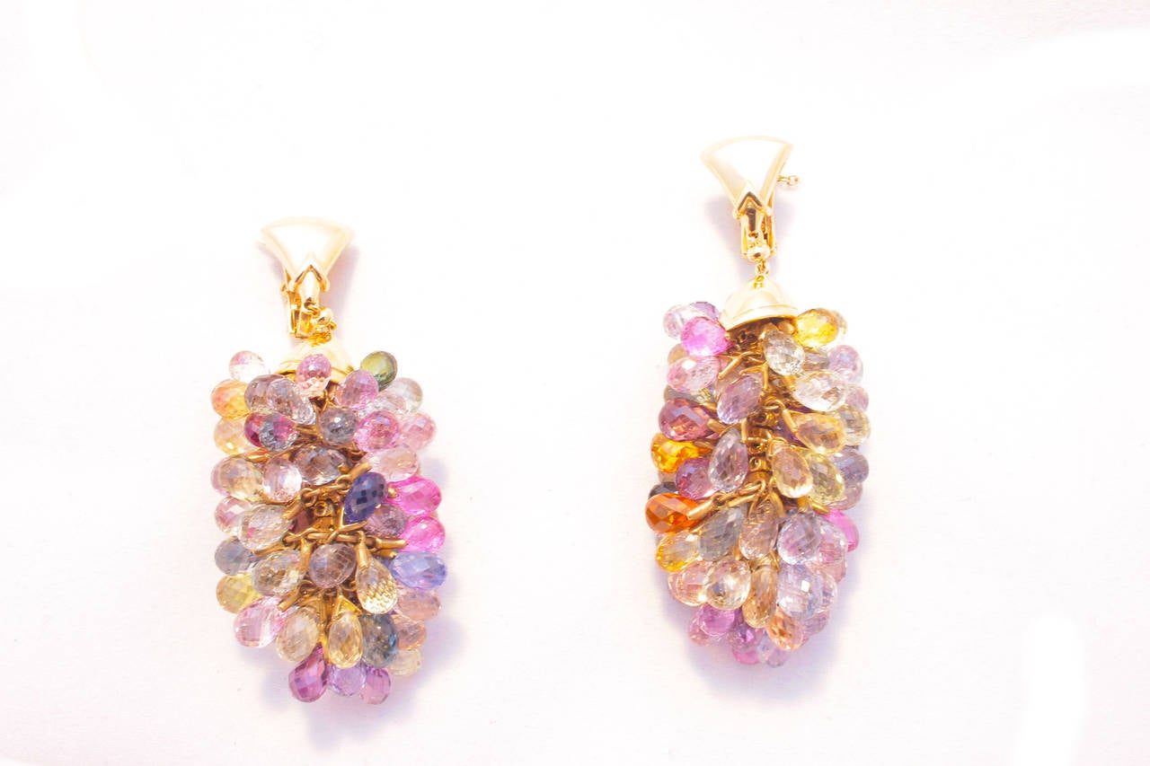 A colourful pair of pendant earrings presenting clusters of briolette cut multicolour sapphires for a total conservative weight of 170 carats, sustained by a fine 18kt yellow gold mounting. Signed Bulgari, circa 1985.