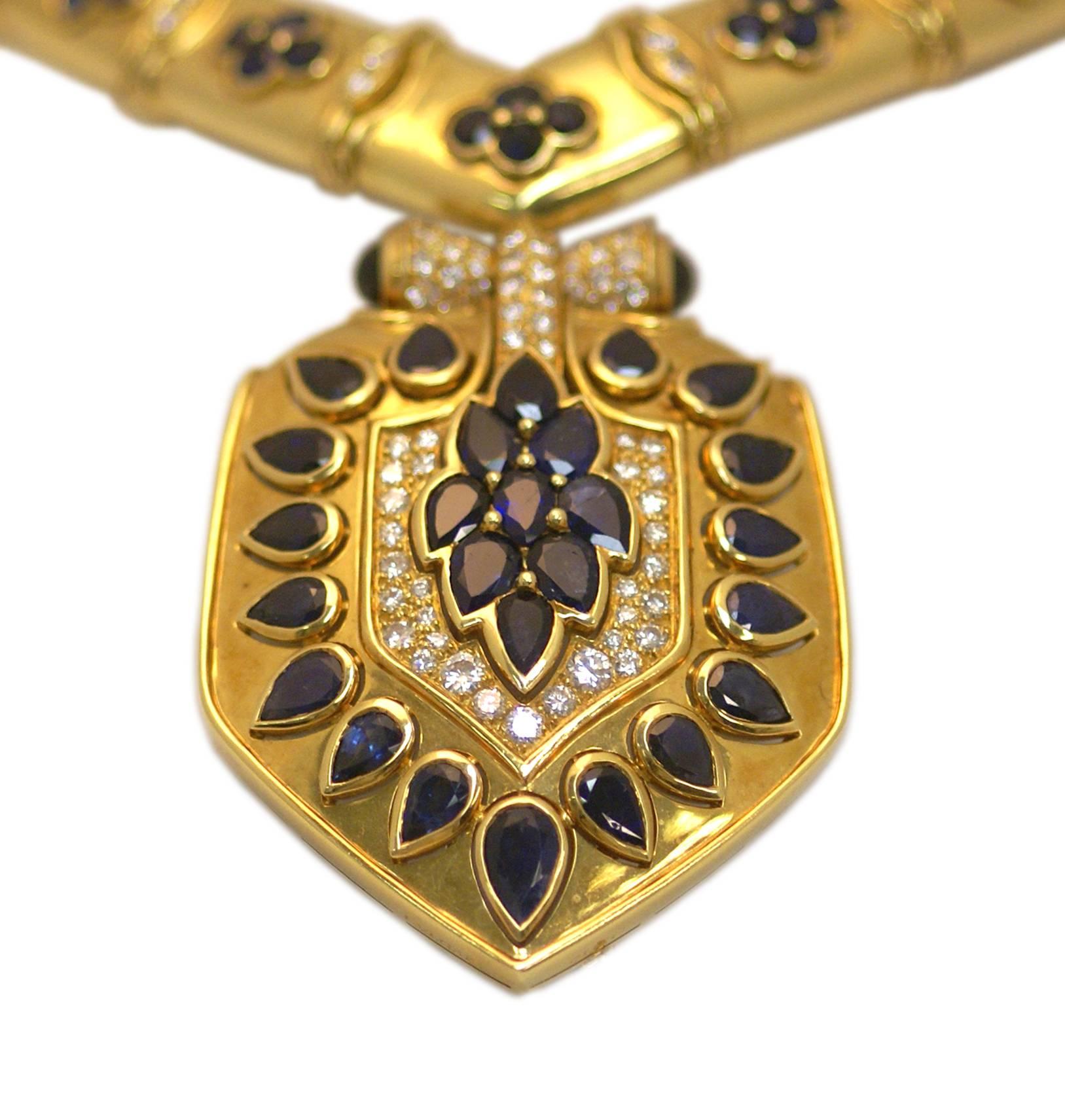 An unusual necklace composed of a V shaped 18kt yellow gold collier, highlighted by round cut sapphires and diamonds, sustaining a large shield (detachable to be worn as a brooch), also embellished with pear shaped sapphires and round cut diamonds.
