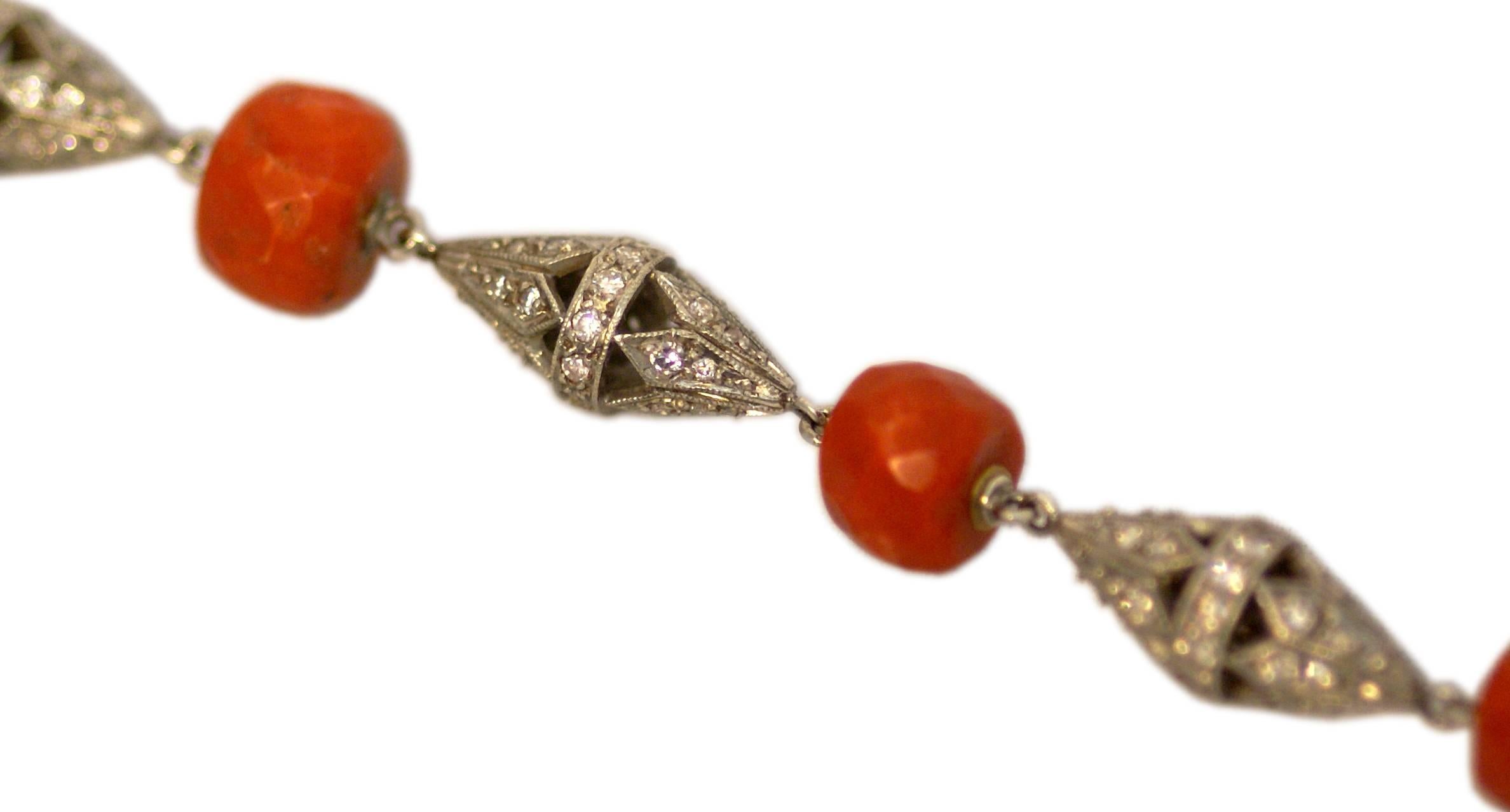 A sophisticated Art Deco link bracelet, interconnecting platinum and diamond cone shaped elements with faceted coral beads. Circa 1920