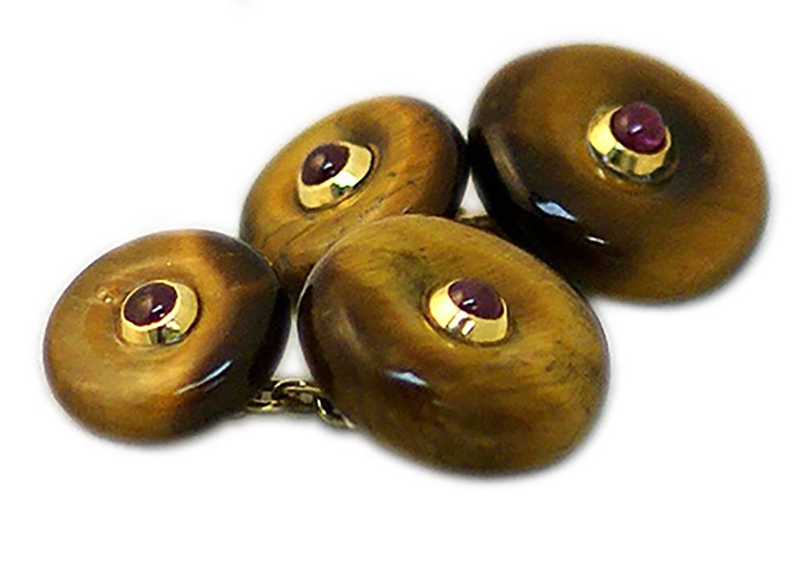 A pair of chic cufflinks made with tiger eye discs, centering four cabochon rubies, mounted in 18kt yellow gold. Italy, circa 1975.