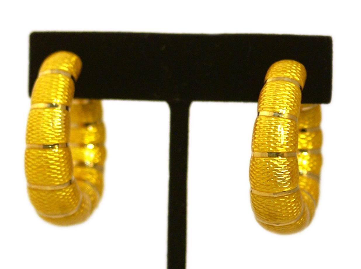 A pair of collectable 18kt yellow gold hoop earrings, highlighted with impeccable yellow enamel work. Signed Bulgari, circa 1970.

