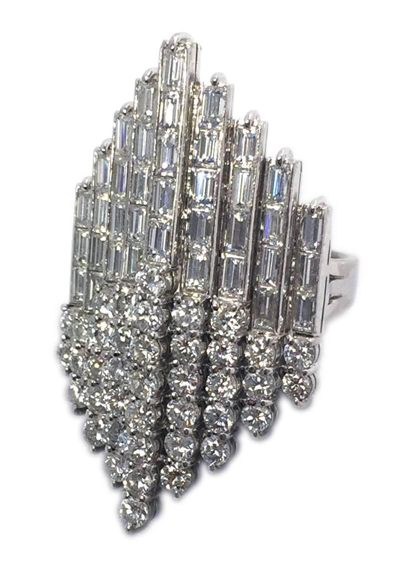 A geometric design diamond cocktail ring, showcasing round and baguette cut diamonds, on a fine 18kt white gold mounting. Circa 1970