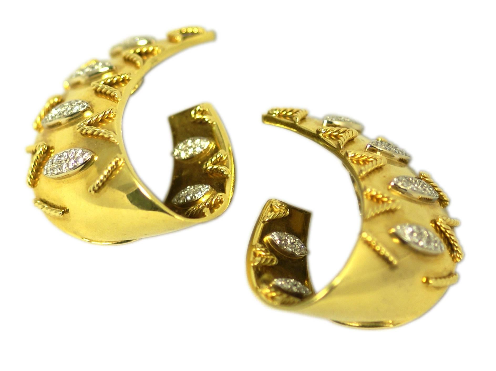 A pair of groovy 18kt yellow gold hoop shaped earclips, highlighted with rope and diamond decorations. Made in Italy, circa 1970.