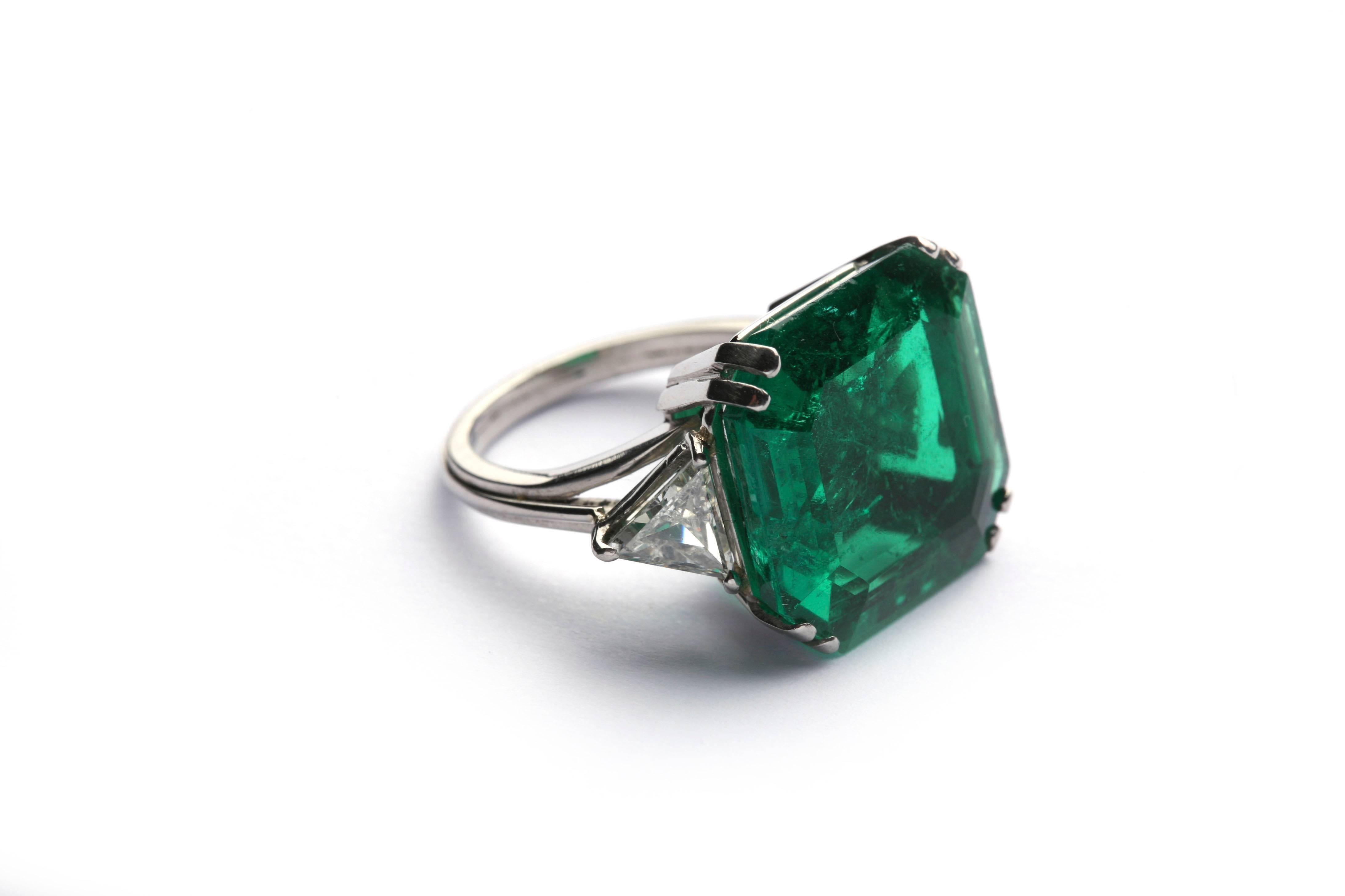 Une bague importante, mettant en valeur une exceptionnelle émeraude colombienne de vieille mine (avec une amélioration traditionnelle insignifiante de la clarté) pesant 17 cts, bordée de deux diamants de taille triangulaire.
