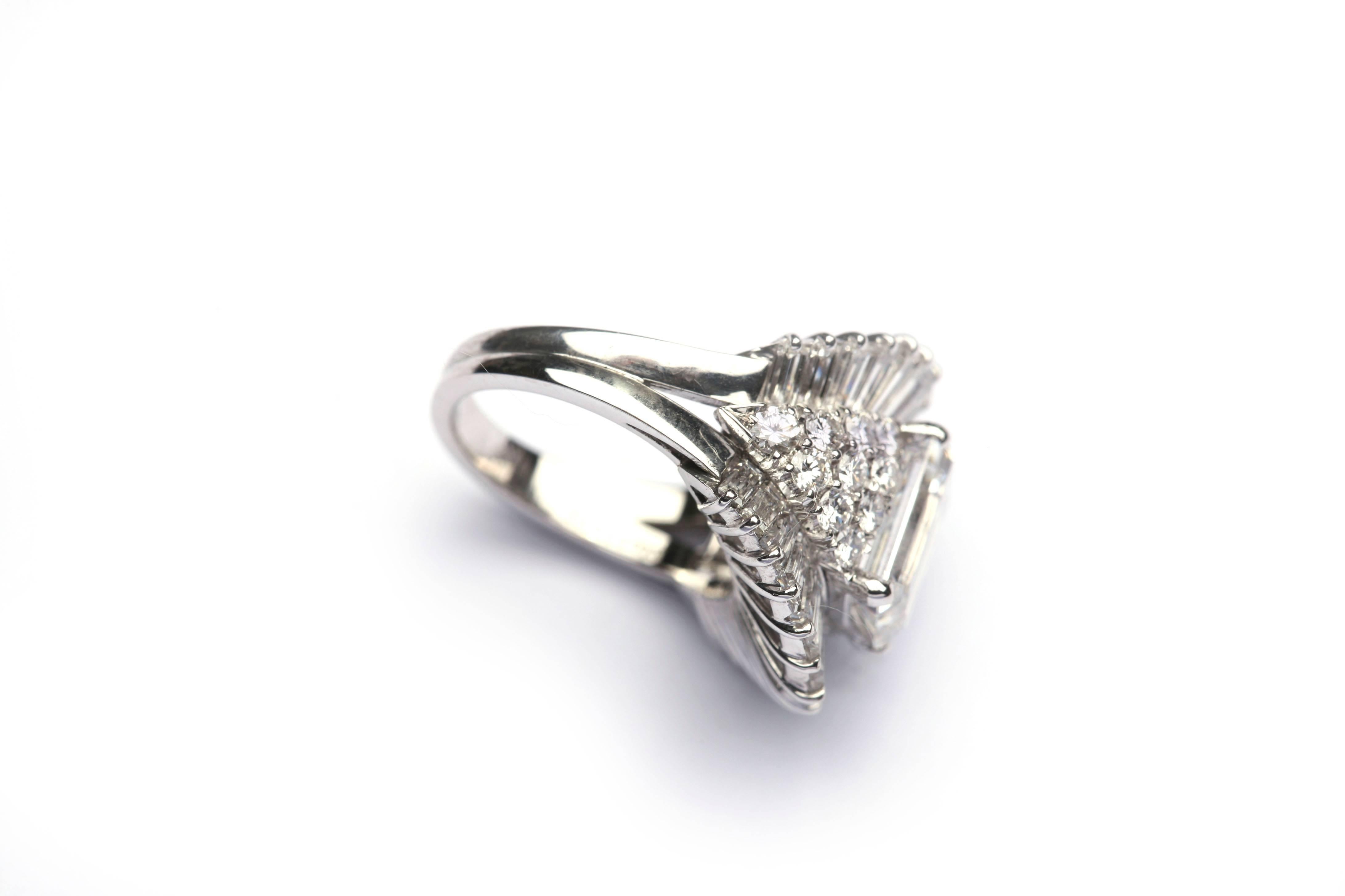 A spiky and sophisticated cocktail/engagement ring by esteemed Roman jeweler Massoni, circa 1980, featuring a 2.66 D VS1 Emerald Cut Diamond, highlighted by baguette and brilliant cut diamonds in a fine 18kt white gold mounting.