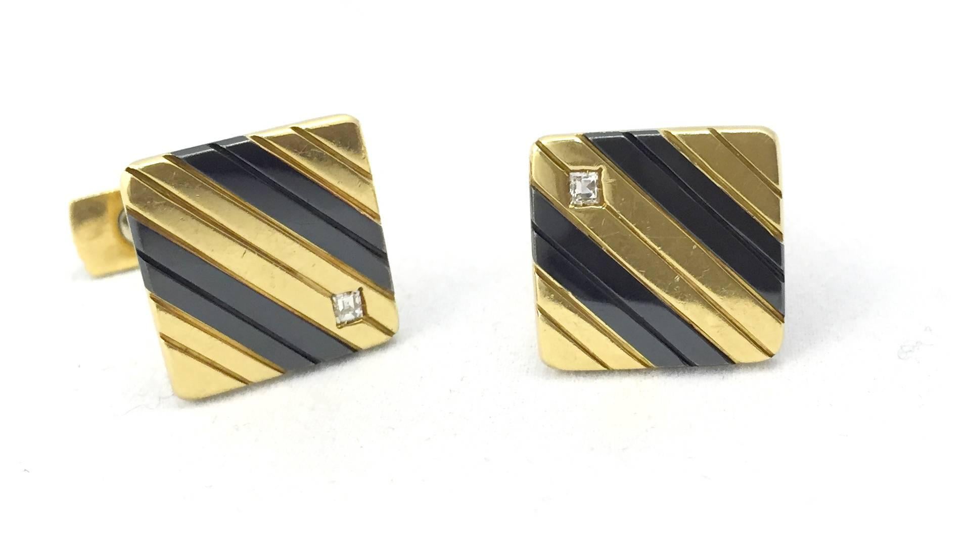 A squared pair of 14kt gold cufflinks decorated with diagonal black enamel sectioning, highlighted with two small squared cut diamonds. Circa 1960 