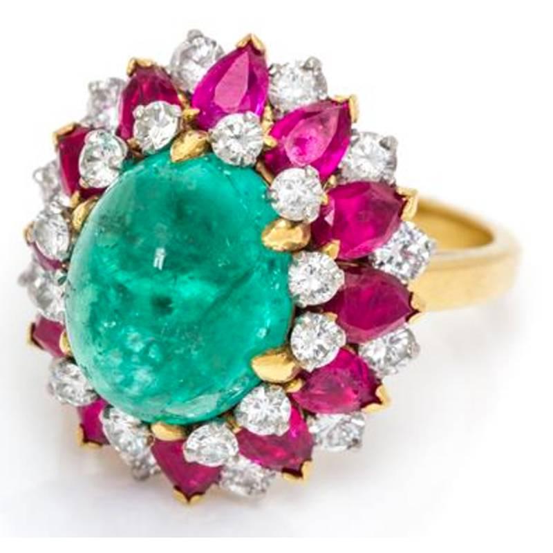 An 18 Karat Yellow Gold, Platinum, Emerald, Ruby and Diamond Bombe Ring by Bulgari, made in Italcirca 1965, containing one oval cabochon cut emerald measuring approximately 11.33 x 9.00 x 7.89 mm, 12 pear shape rubies weighing approximately 2.76