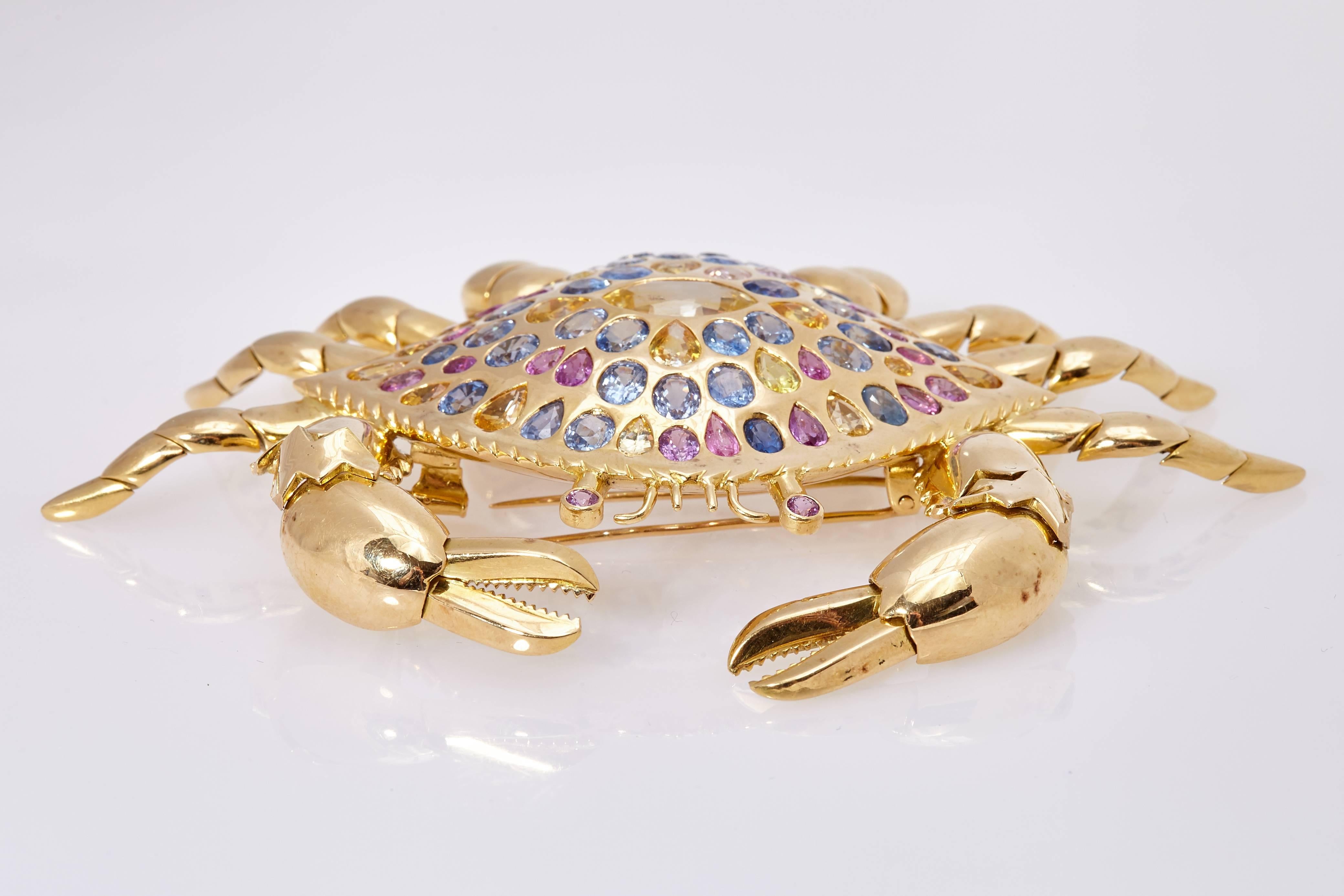 An impressive, large and articulated crab brooch. Made in 18kt yellow gold, enriched with 21 carats of multicolor sapphires. Circa 1980s 