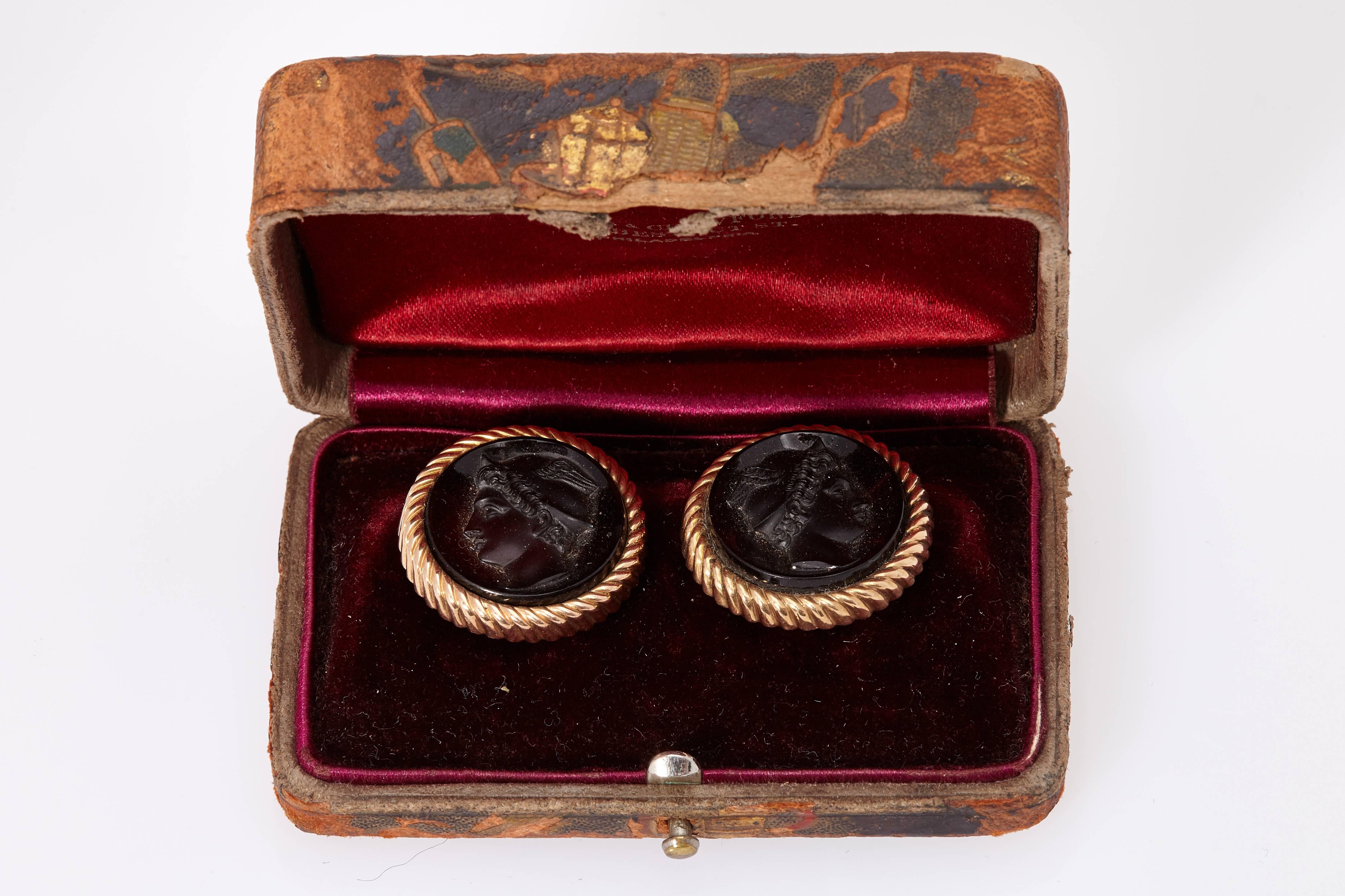 A pair of chic chic amber and rose gold cufflinks, representing the profiles of Venus and Mercury, in their original box. Dated November 1980. 