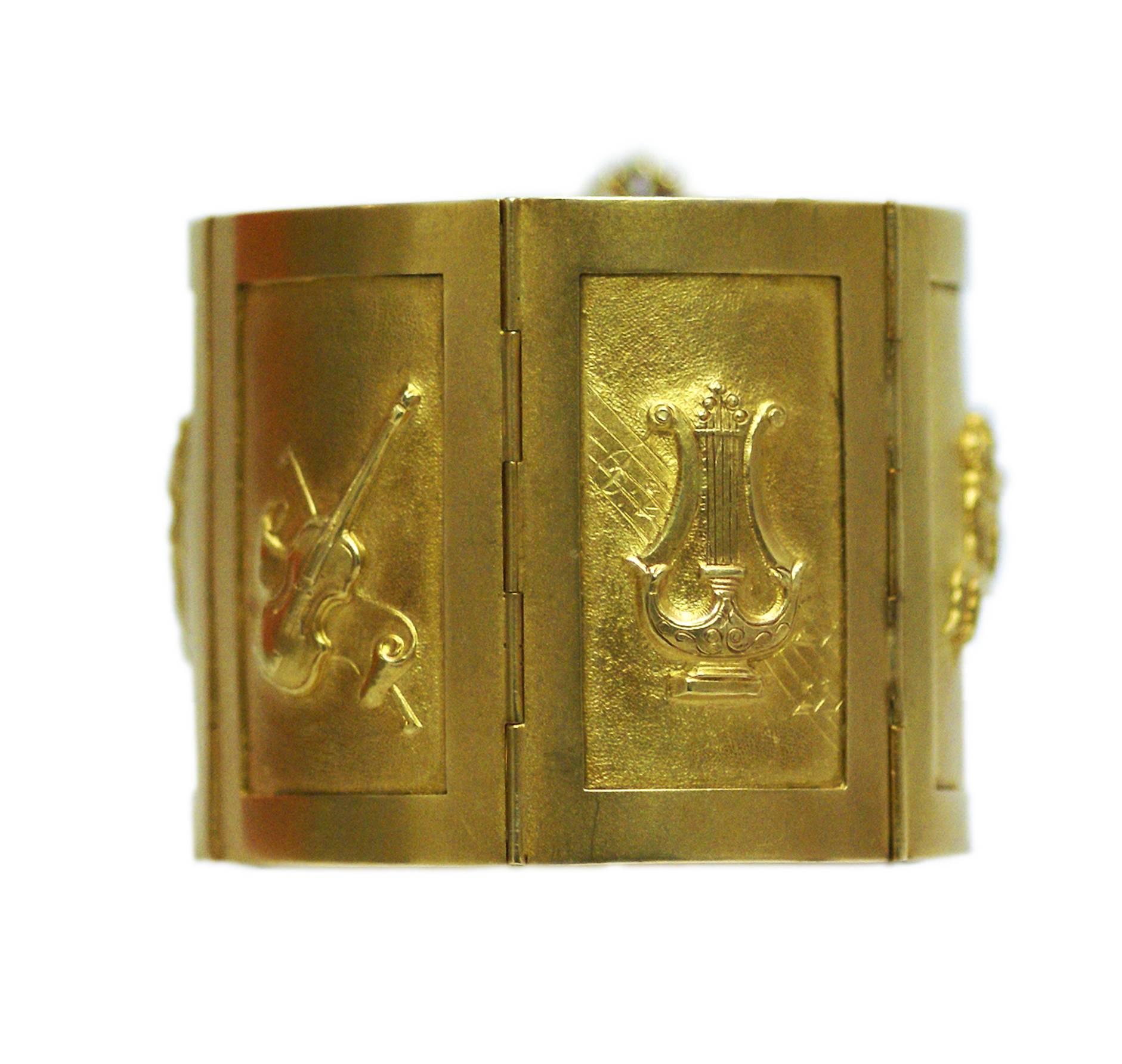 An unusual and large gold bracelet by historical Roman jeweler Mortet, representing musical instruments, mythological scenes and Trajan's column in Rome. Circa 1975