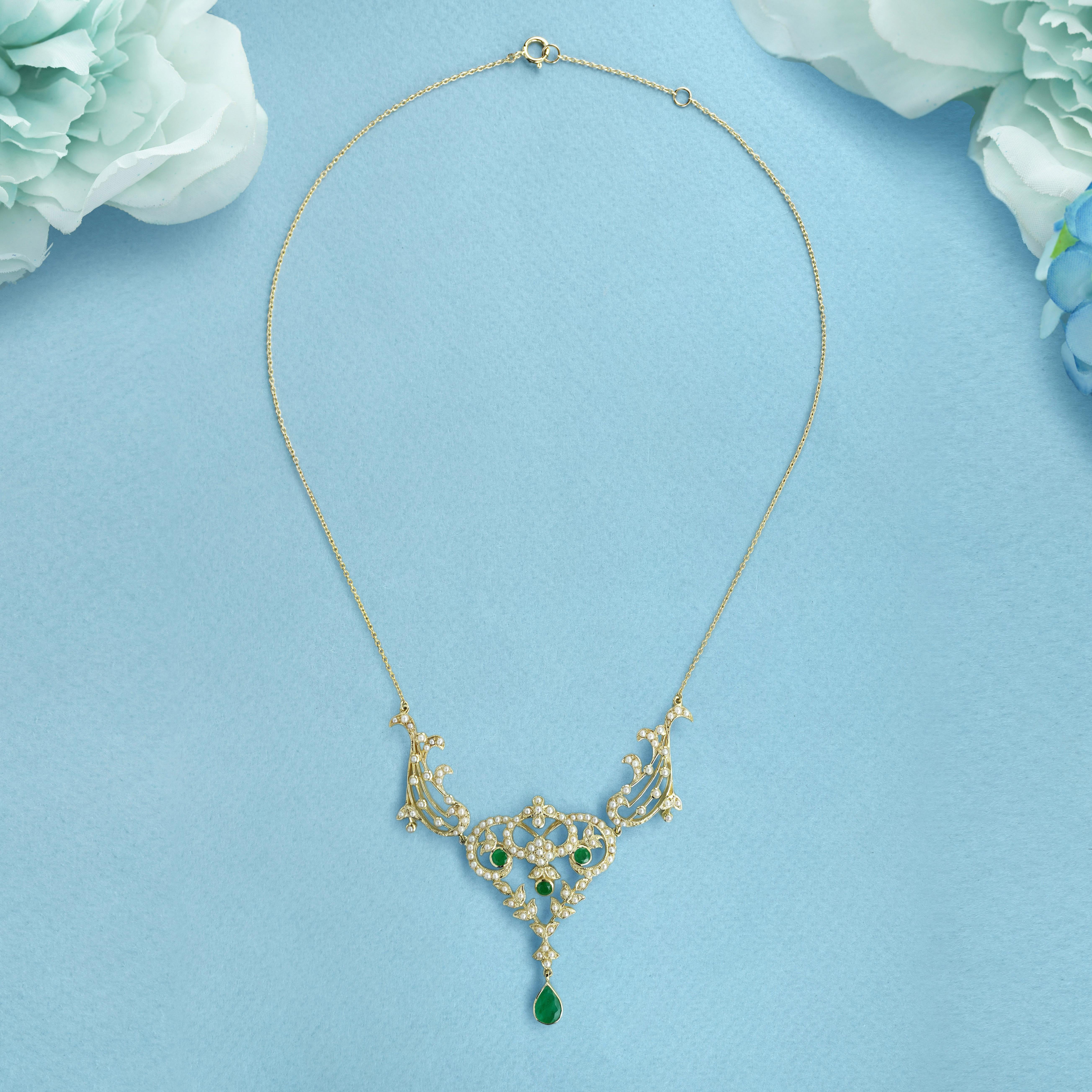 Questa splendida collana in stile vittoriano presenta uno smeraldo naturale a forma di pera come goccia centrale, elegantemente sospeso sotto intricati dettagli floreali. La parte superiore del disegno è ornata da perle lucenti, che esaltano la