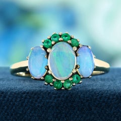 Anillo de tres piedras con ópalo y esmeralda ovaladas, en oro amarillo de 9K
