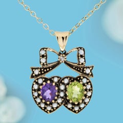 Colgante de doble corazón con lazo, de amatista, peridoto y perla, en oro amarillo de 9K