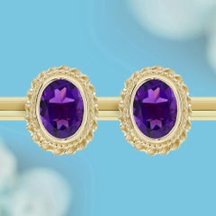 Pendientes de botón con amatista ovalada y diseño de halo con motivo de cuerda, en oro amarillo de 9K
