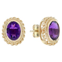 Pendientes de botón con amatista ovalada y diseño de halo con motivo de cuerda, en oro amarillo de 9K