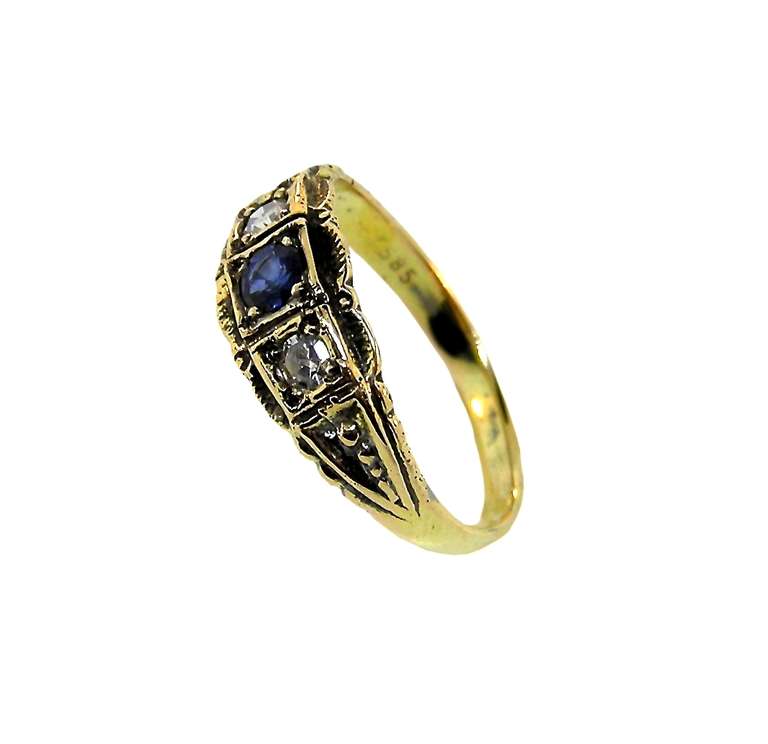 This exquisite piece is 14K yellow gold, from Europe.  With a .15-carat blue sapphire and two .05 carat each, round, antique, single-cut diamonds.