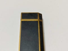 Encendedor vintage de Cartier de metal en tonos negro y dorado