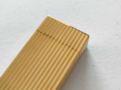 Accendino Cartier vintage in metallo dorato con finitura a coste