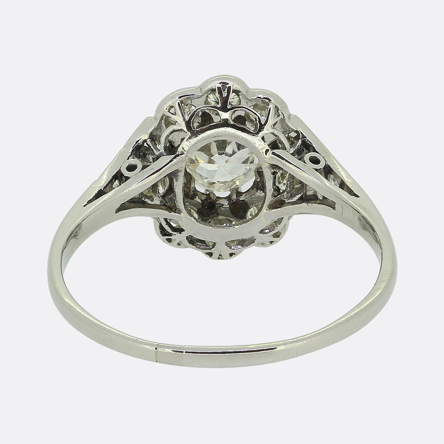 Nous avons ici une magnifique bague à grappes de diamants fabriquée à une époque où le style Art déco était à son apogée. Un diamant rond facetté de taille européenne ancienne est légèrement surélevé dans une monture à huit griffes au centre de la