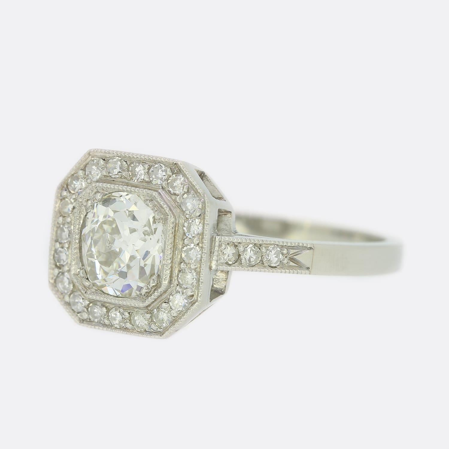 This is a wonderful diamond cluster ring. The ring has been masterfully handcrafted in an Art Deco style and features a stunning 0.75 carat old cut diamond which sits in a claw setting and is surrounded by a hexagonal shaped diamond halo with