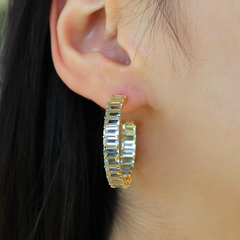 The Ariel Aquamarine Inside-out Large Hoop Earrings in 14k Gold are a stunning blend of contemporary style and timeless elegance. The inside-out design ensures that the brilliance of these gemstones is visible from every angle, creating a dazzling