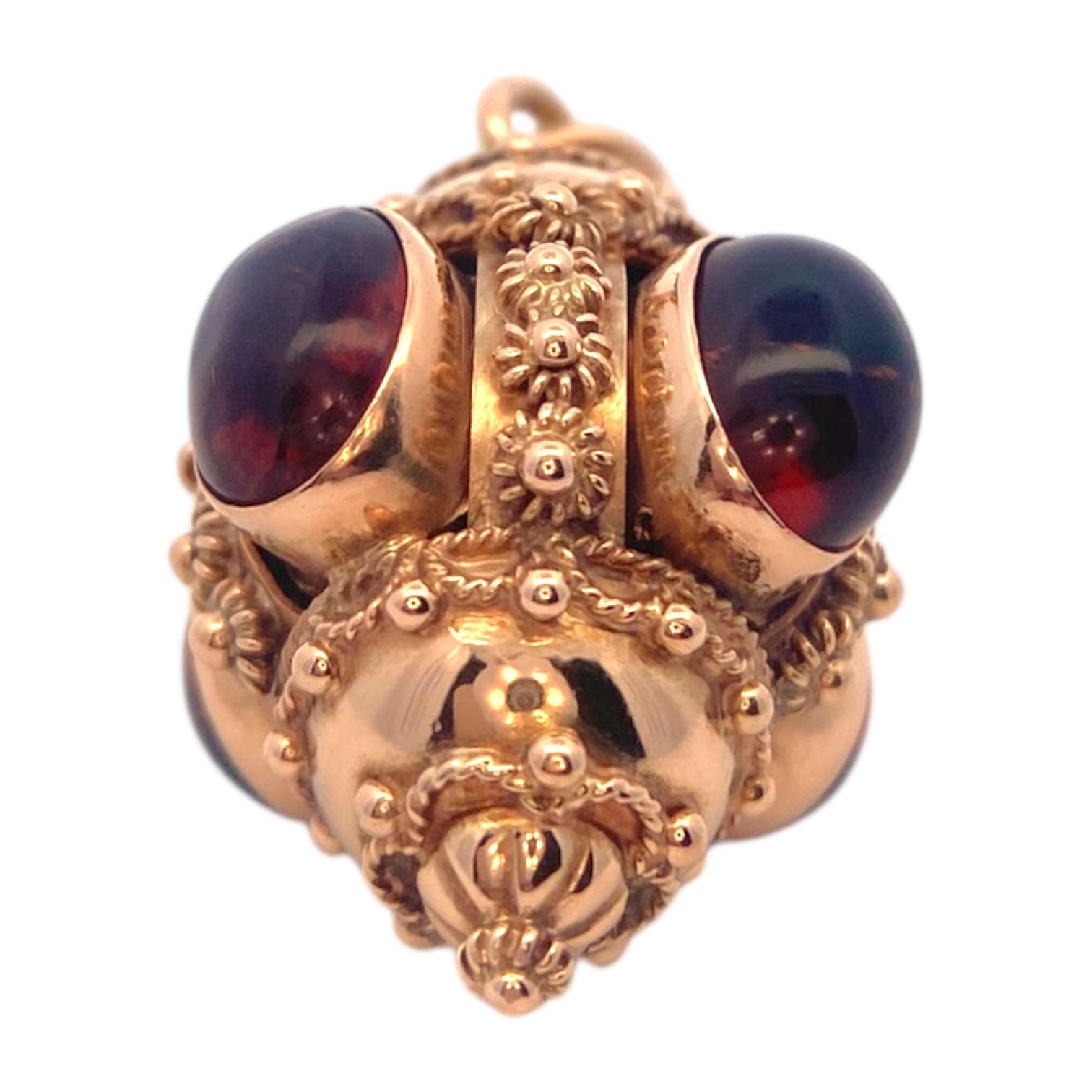 Fabriquée en or jaune 18 carats, cette breloque présente des détails complexes de style néo-étrusque. Quatre citrines taillées en cabochon, chacune d'une riche teinte orangée, sont placées en évidence au centre du pendentif. L'or est orné de