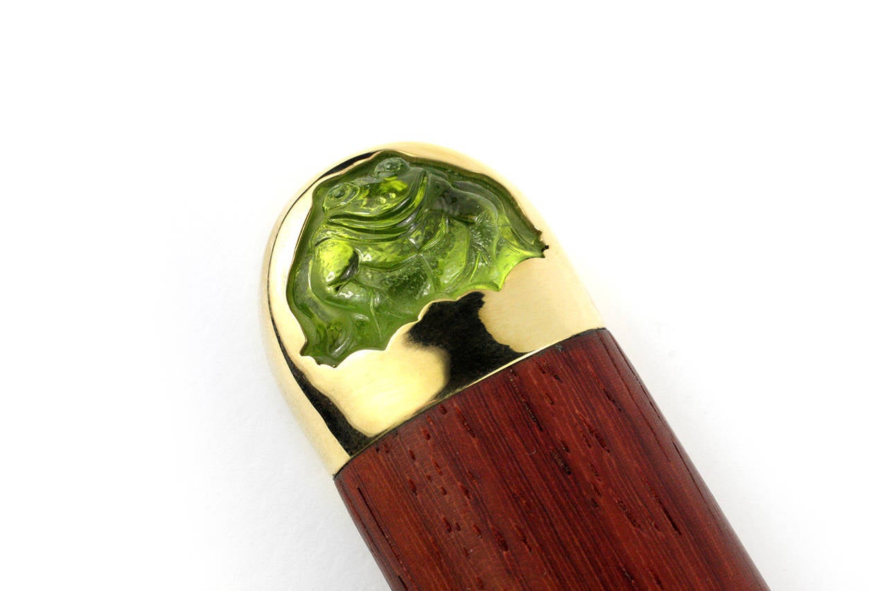 This beautiful letter opener is made with 18KT Gold, silver and rosewood and contains 2 carved Peridot frog pieces. Designed and made in-house by Julius Cohen New York.