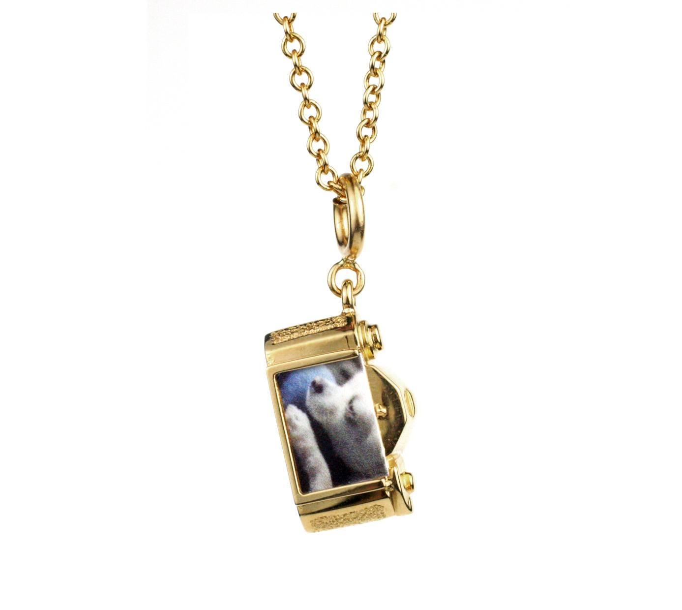 This beautifully made, solid 18 KT Gold Camera charm features a turning, adjustable focus and polished Platinum lens.  It also has an open, slide-in 3/4 frame to include a  special photo or message.  Price includes an 18KT Gold Neck Chain (18