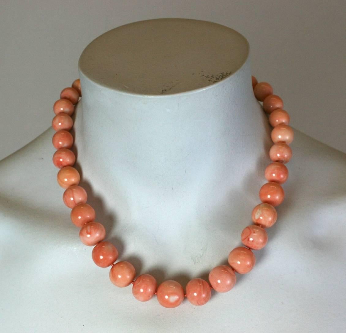 Elegant Natural Coral Beads in marbleized, pink and creamsicle tones. Elegant etched 18k gold clasp with central coral cabochon and 6 bezel set diamonds. 1960's USA. 
Excellent condition and substantial bead size. 
17