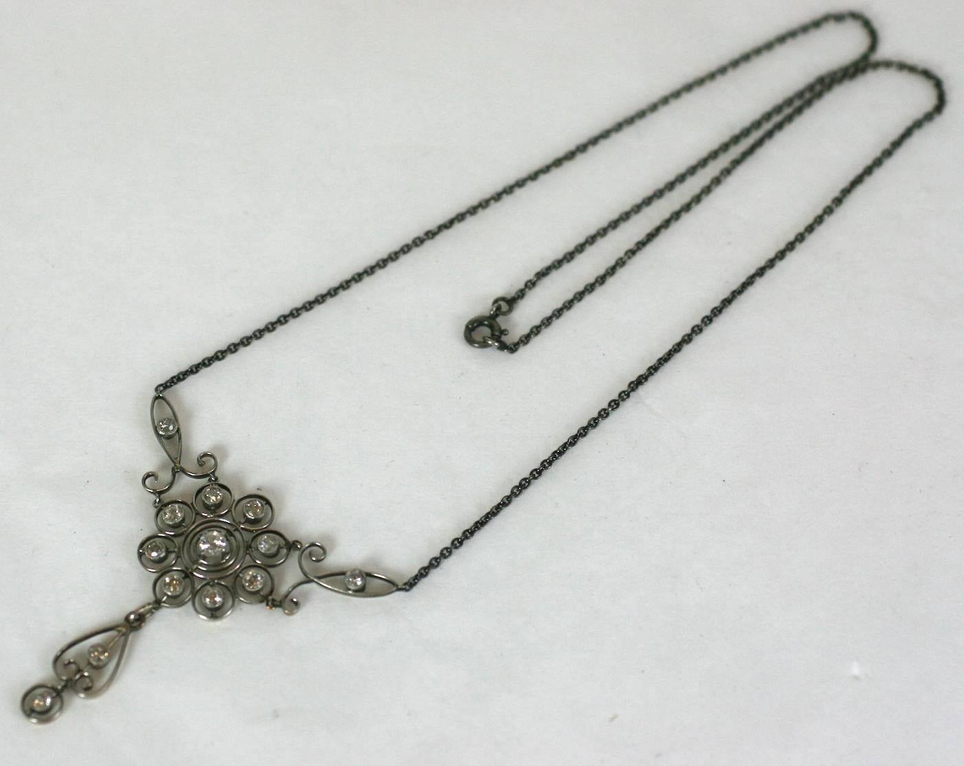 Edwardian Diamond Pendant necklace circa 1900. Openwork settings are made of platinum topped 14k gold set with 13 fine quality, antique cut diamonds. The smaller stones are bezel set in mille grain settings while the center stone is prong set. The