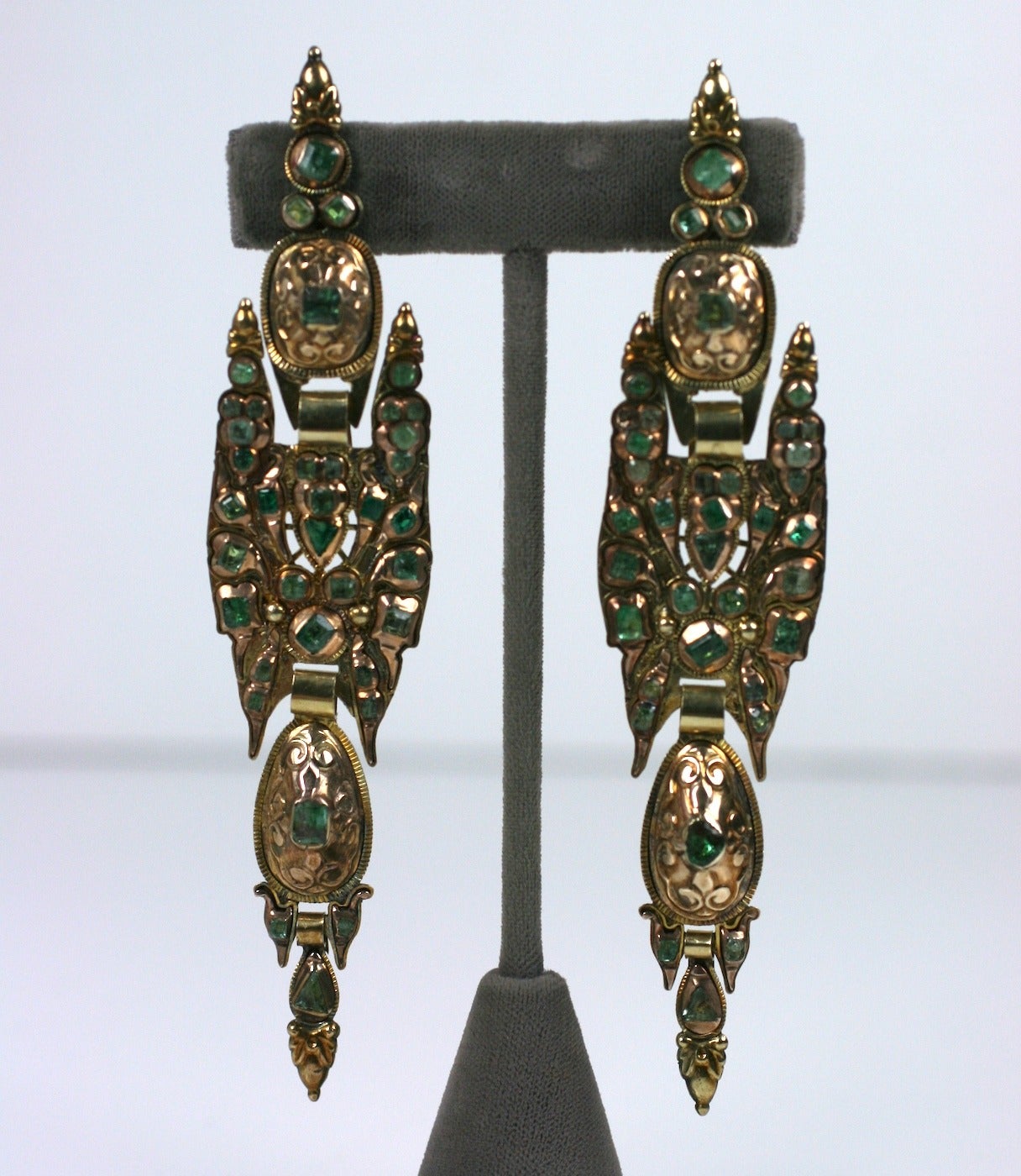 Late 18th Century articulated Iberian emerald earrings of large scale. 
Vari colored and cut foiled emeralds are set high in the gold mounts in the traditional forms of this Spanish region. Attractive and large in scale, but, not heavy in weight