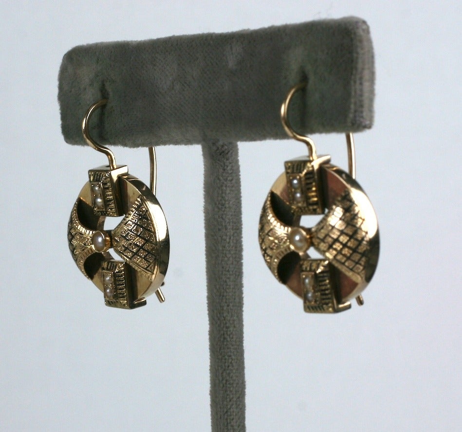 Victorian 14k gold and enamel earrings of high quality with original ear wires and black enamel. 
The design is basically a disc with superimposed enameled winged elements at the center and rectangles at the top and bottom. There are tiny seed