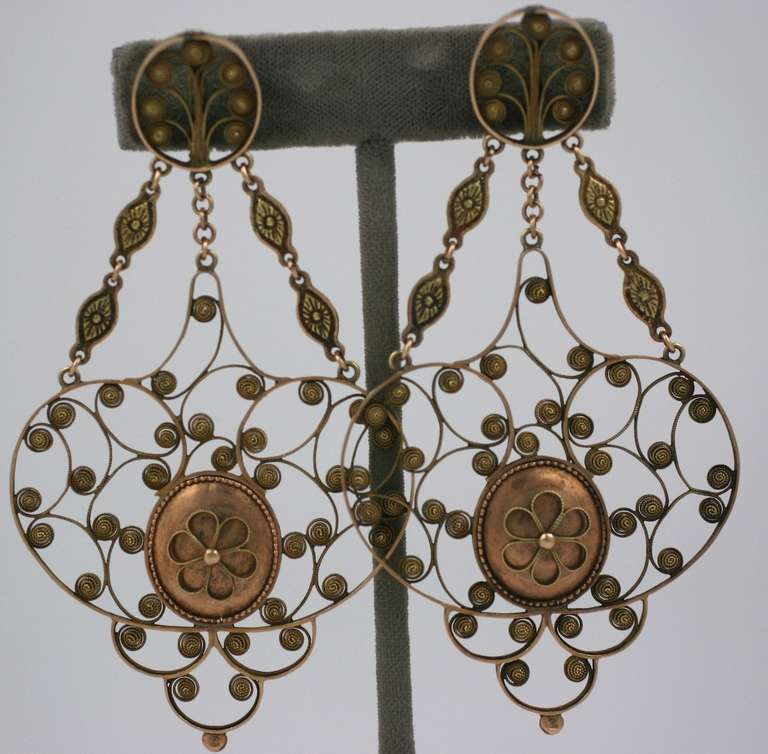 Massive and extraordinary early 19th Century Georgian earrings of low carat gold, likely of Italian origins. Elegant swirled cannetille work form openwork decorated pendants are suspended by etched marquise shaped gold links.
Large and imposing