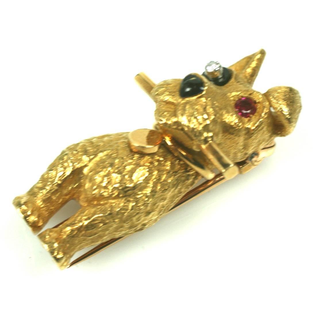 Faithful terrier clip-brooch in 18k gold with onyx eye patch, bezel set diamond, and ruby eye by Cartier, Paris. Beautifully modeled, finely detailed, with ID collar/charm and prized stick in mouth. 1950's France. Excellent condition.
1.5