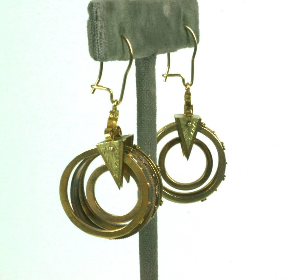 Extremely unusual Victorian Earrings in the Archeological Revival style, constructed of a series of gold hoops in varicolored gold (green and pink), decorated with tiny shot work and flower heads. These are held in place by an engraved triangular