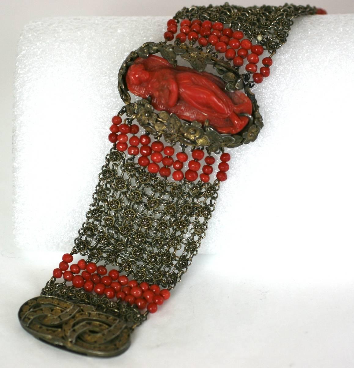 Large Victorian Coral Bracelet of gilded silver with ornate leaf and cannetille wirework mesh. A large high relief coral cameo of a maiden with a bouquet of fruit is the centerpiece of the bracelet. The lovely cameo is mounted in a floral leaf