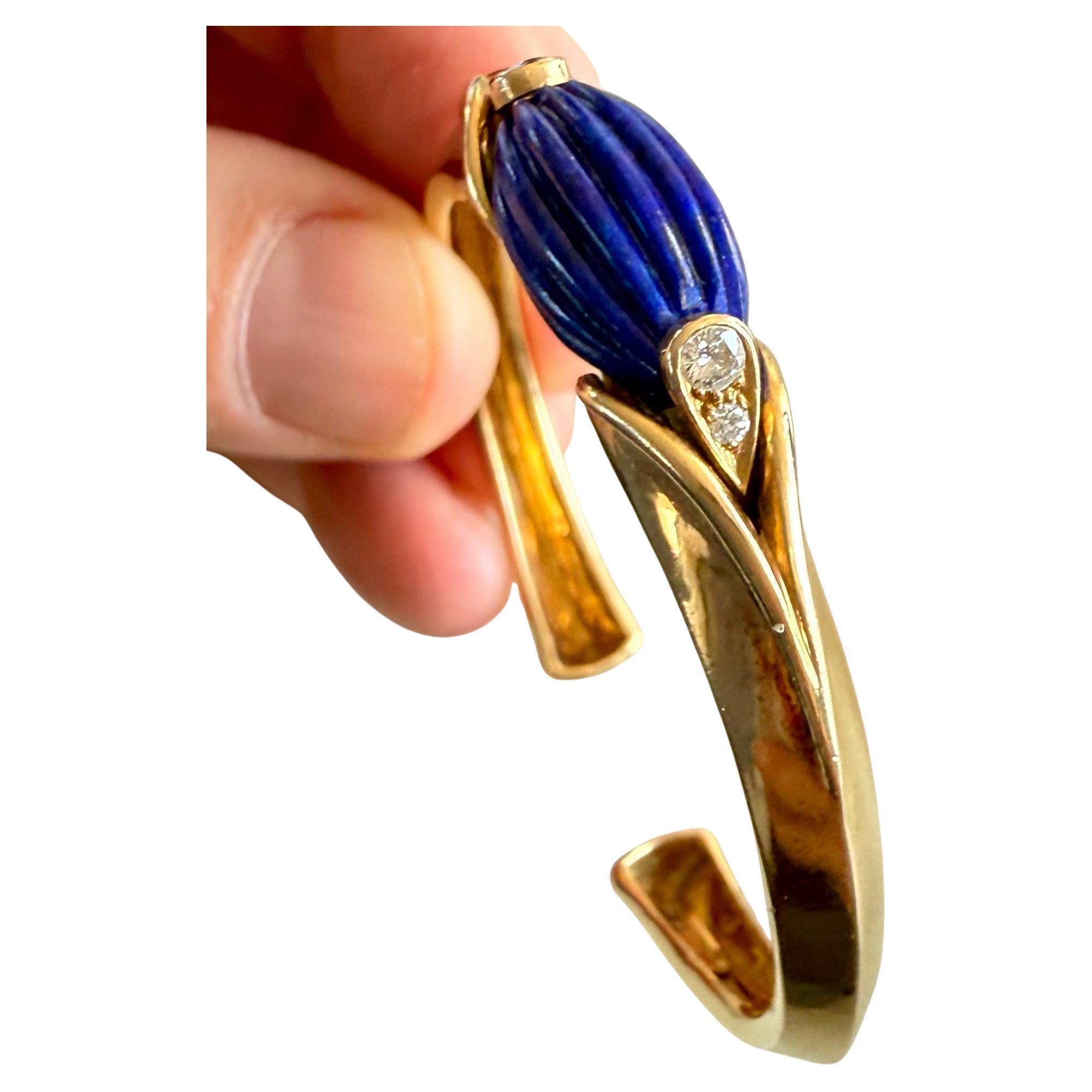 Este exquisito brazalete Van Cleef & Arpels representa una obra maestra de la alta joyería francesa de 1971. Meticulosamente elaborada a mano en oro amarillo de 18 quilates, esta pieza histórica exhibe una impresionante gema de lapislázuli de
