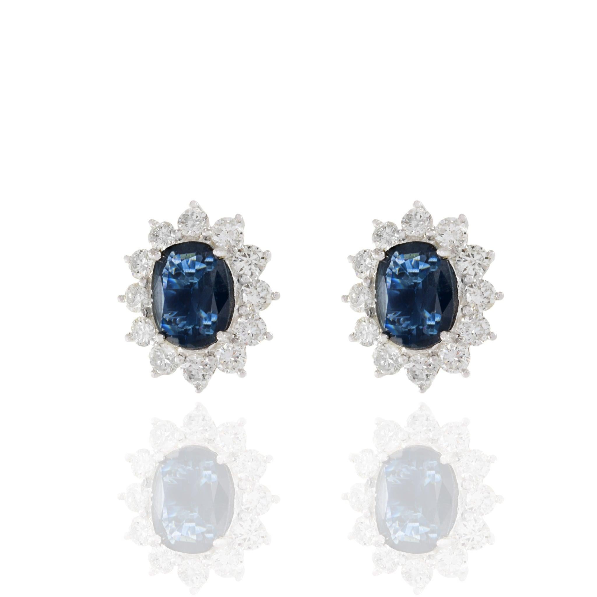 Laissez-vous séduire par une élégance intemporelle avec ces boucles d'oreilles fabriquées par des experts. La pièce maîtresse de chaque boucle d'oreille est un magnifique saphir bleu de taille ovale, totalisant 3,04 carats, entouré de 1,35 carats-TW