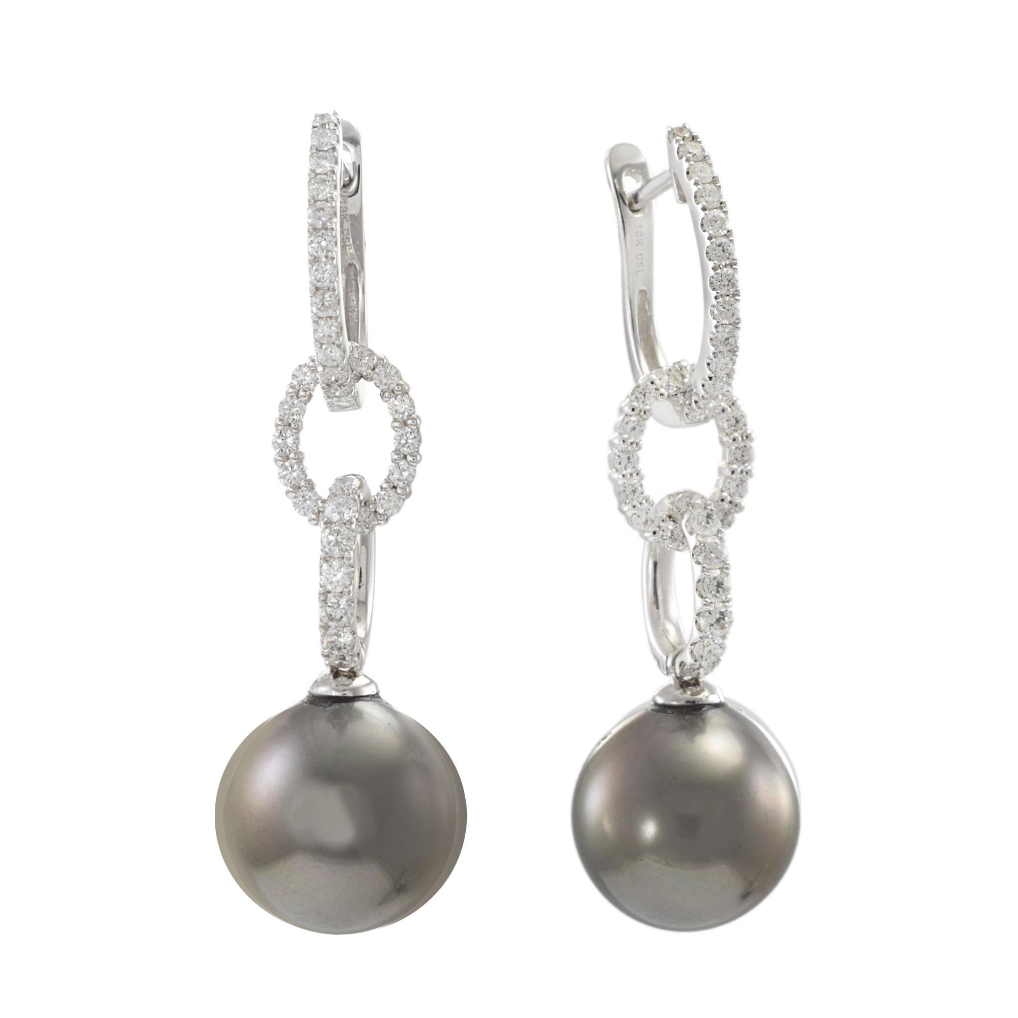 Élevez votre élégance avec ces étonnantes boucles d'oreilles pendantes, réalisées en or blanc 18KT lumineux. Chaque boucle d'oreille met en valeur une magnifique perle de Tahiti de 11 à 12 mm, célèbre pour son éclat profond et naturel. Suspendues à