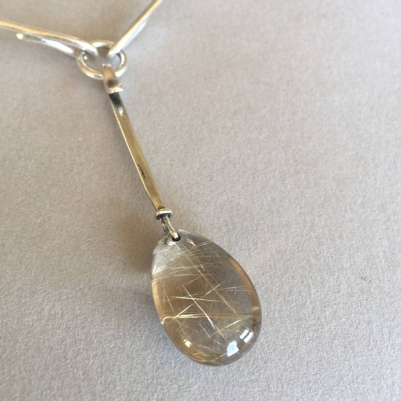 Georg Jensen sterling silver collar, no. 198 by Bent Gabrielsen with rutilated Quartz drop, no. 128 by Vivianna Torun. Denmark. 

This collar allows the wearer more flexibility as it is hinged.

Measures 6