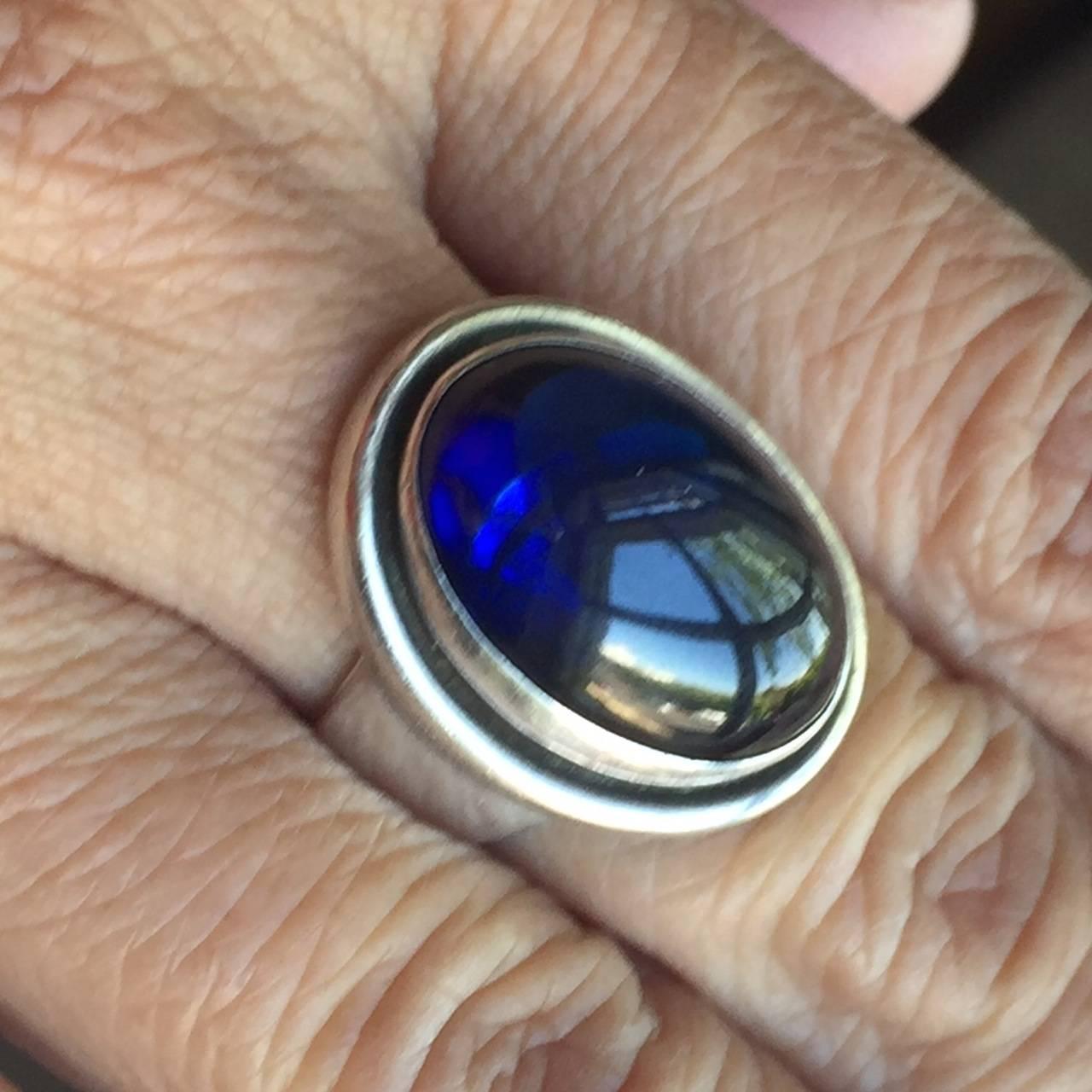 Georg Jensen Sterling Silver Synthetic Sapphire Ring No. 46A by Harald Nielsen.

Stunning sterling silver ring in excellent condition. The 46A ring usually has a silver backing but this one does not to allow light to shine through the fabulously
