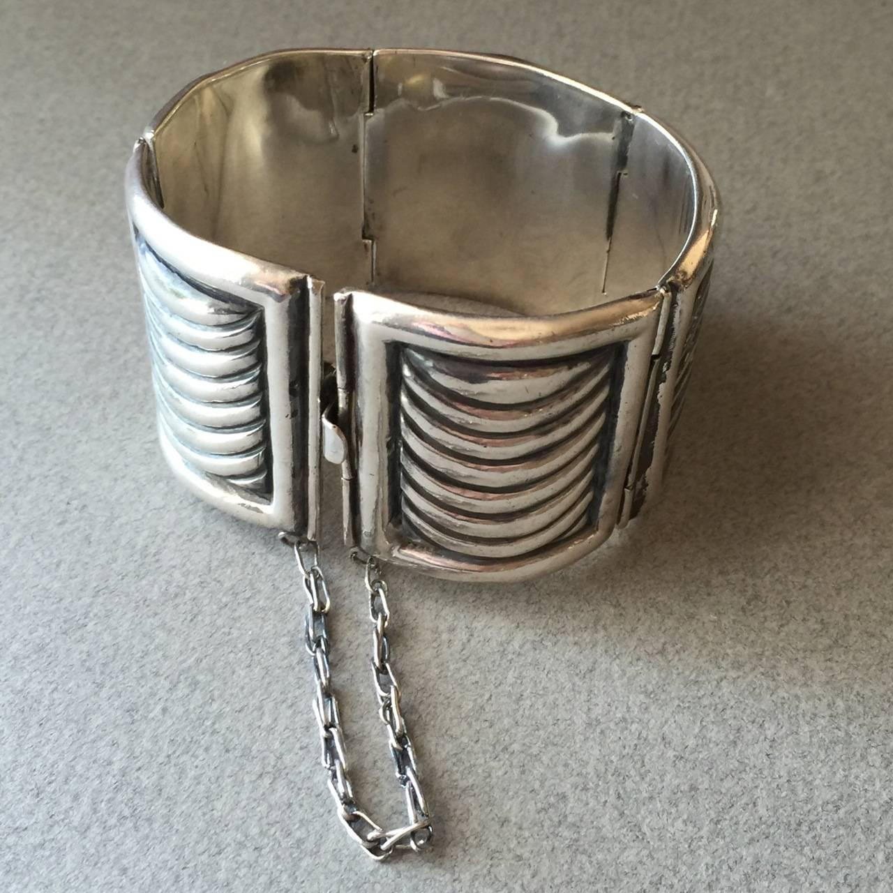 Fred Davis Sterling Silver Bracelet

This remarkable bracelet by master silversmith Fred Davis consists of five panels with curved lines connected by hinges. The hinged panels curve slightly for comfort. 

It makes a great statement on the wrist