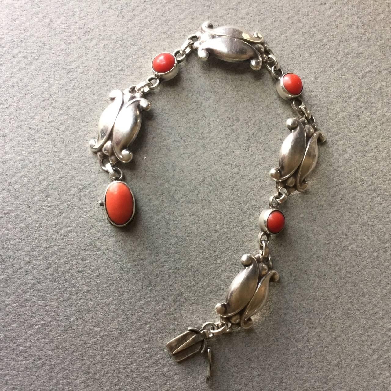 Georg Jensen Sterling Silver Bracelet No. 11 with Coral.

Lovely bracelet with beautiful patina. The coral stones are vivid and in great condition.

A similar example can be found on p. 116 in the book, 