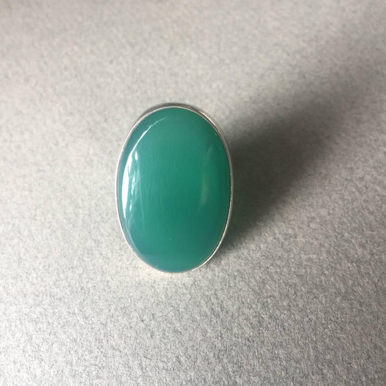 Georg Jensen Modernist Sterling Silver Ring No. 90A with Chrysoprase.

Large domed Chrysoprase Cabochon. There are natural inclusions in the stone.

The open back adds to the beautiful translucency of the stone. 

Ring Size: 7.5

Complimentary gift