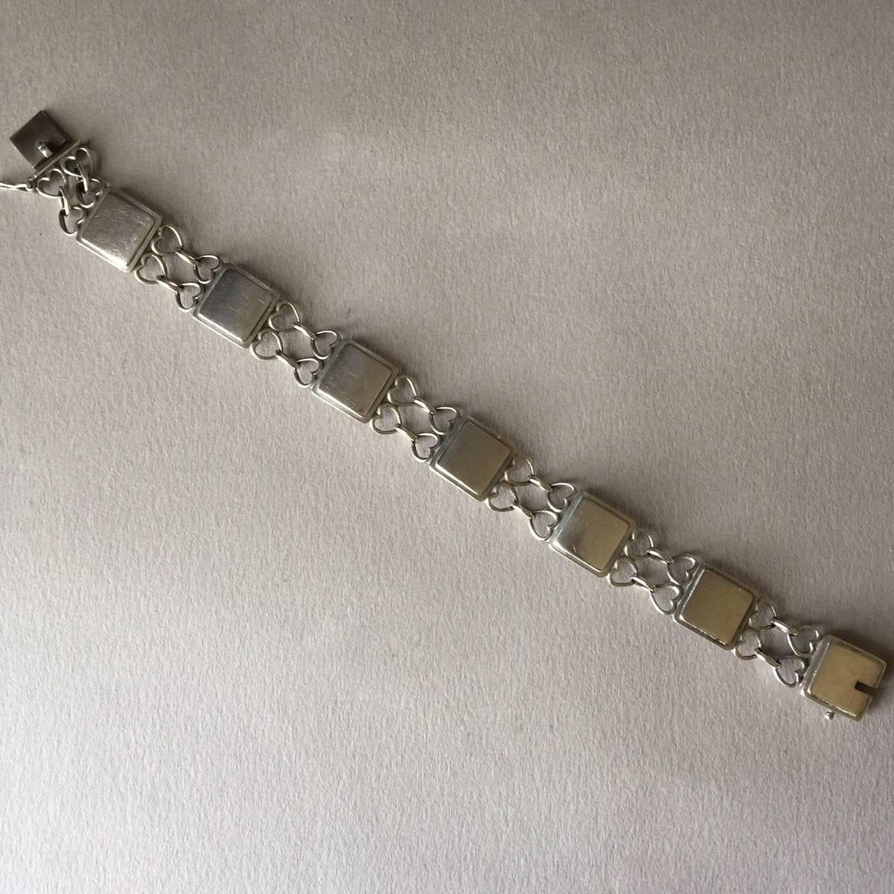 Georg Jensen Sterling Silver Bracelet No. 70 by Arno Malinowski.

Beautifully detailed stylized heart bracelet, alternating squares and heart shaped links. Art deco design.

Made of sterling silver. Excellent condition.

Complimentary gift box and